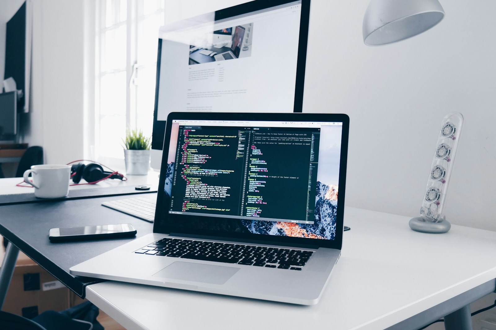 Laptop on a desk showing a web development workspace